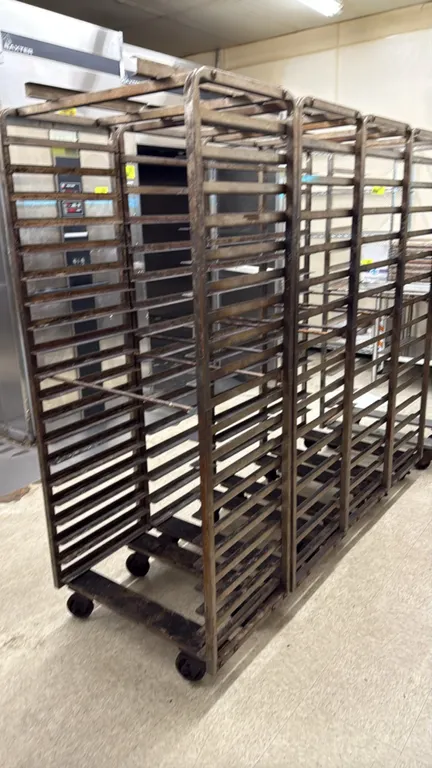 Side-load roll-in oven racks. Features steel construction, multi-tier side-load pan slides, and top rack oven lift attachment. Mounted on swivel caste