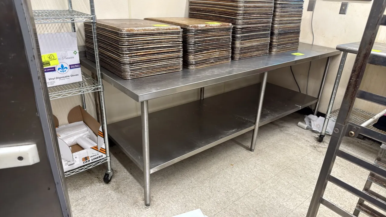 Stainless steel work table. Features stainless steel undershelf and tubular legs with adjustable bullet feet. 96" x 36". Contents not included.