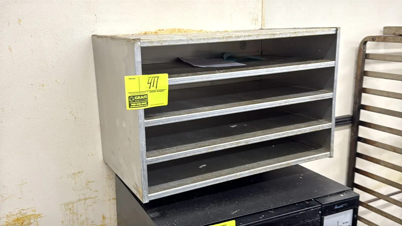 Aluminum wall-mounted shelf organizer cabinet. Features 4-tier open storage slots and aluminum construction. 24" x 15". Wall-mounted design. Contents