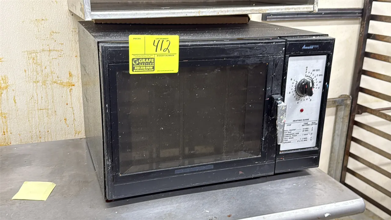 Amana commercial microwave. Features rotary dial timer, printed heating guide, and side-hinged door with pull handle. 21.5"W.