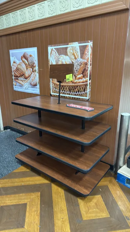 Portable 4-tier laminate island merchandiser. Features woodgrain laminate shelves with black protective bumper edging and top sign holder. 52"L.