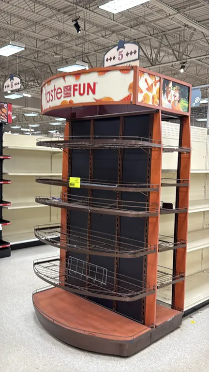 Portable endcap retail display unit. Features top graphic header canopy, woodgrain-accented frame and base, adjustable curved front wire shelves, and