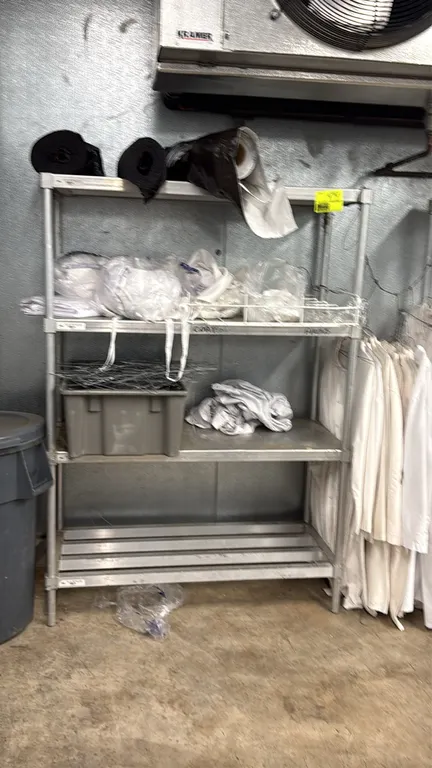 Aluminum 4-tier shelving rack. Features solid shelf tiers and a bottom slatted shelf. 48" x 20" x 68". Contents not included.