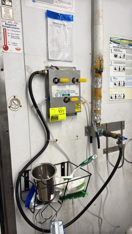Hydro Systems HydroChem chemical dispenser. Features stainless steel housing, (3) control valves with yellow handles, and dispensing tubing. Wall-moun