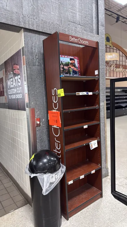 Laminate merchandiser display shelving unit. Features woodgrain finish, 'Better Choices' header, and adjustable shelves. 2'W. Contents and background