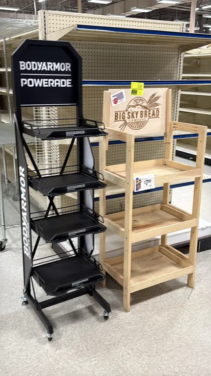 Assorted merchandise display racks. Includes (1) Bodyarmor Powerade 4-tier metal display rack on swivel casters and (1) Big Sky Bread Company 3-tier w