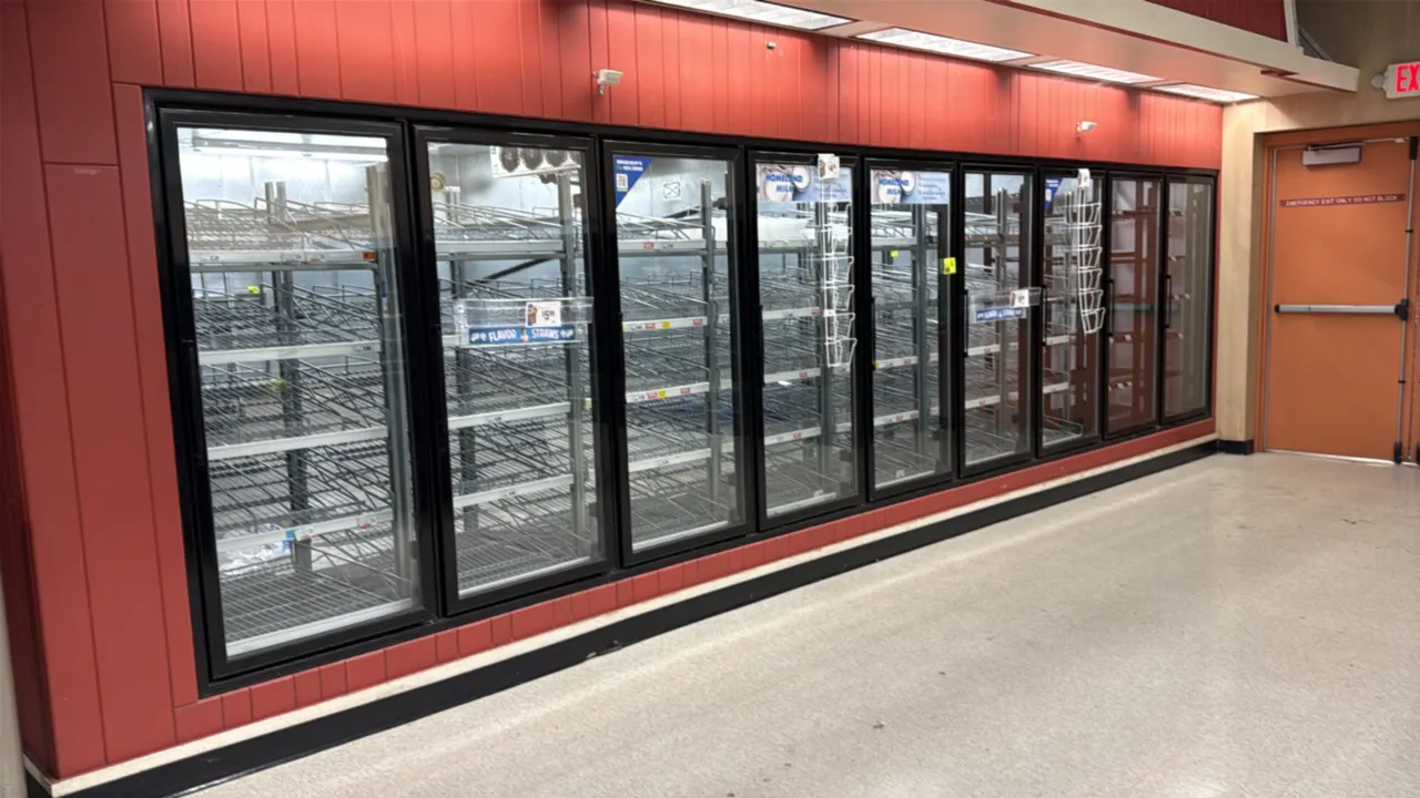 Dairy walk-in cooler. Features insulated foam panels, (9) Anthony glass display doors with gravity-feed wire shelving, pallet entry door with diamond