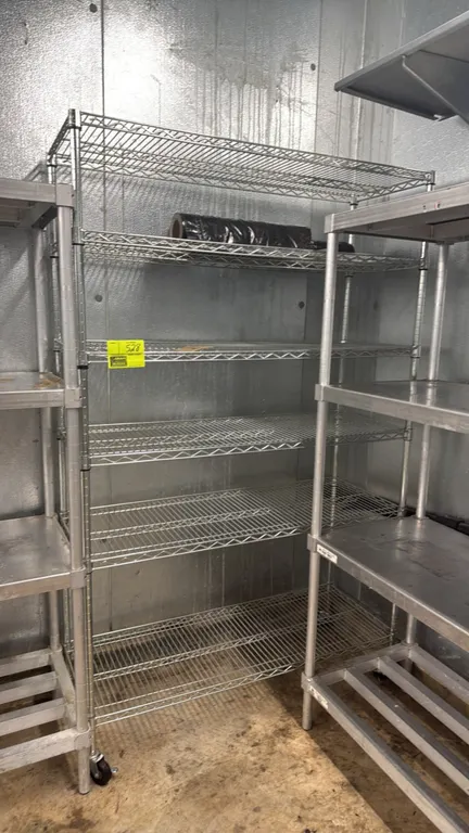 Metro-style mobile wire shelving rack. Features (6) adjustable chrome wire shelves. 48"W x 18"D x 73"H. Mounted on casters. Contents and surrounding s