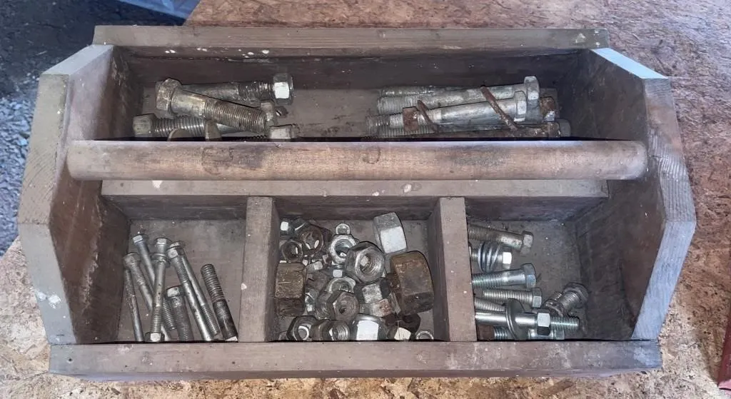 Wooden tool caddy with nuts and bolts.