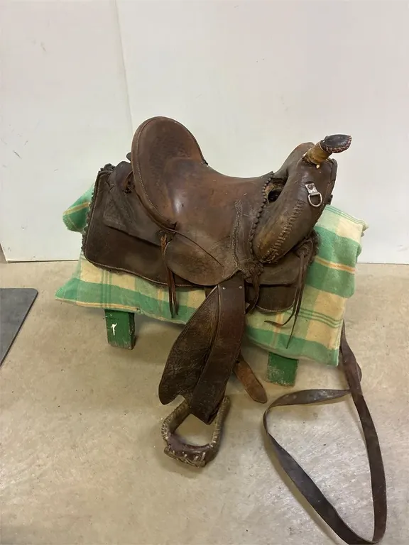 High back saddle. Needs oiling. Can’t read the