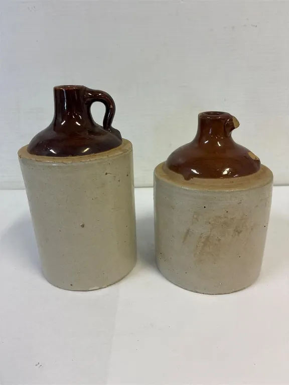 2 small pottery jugs. 1 broken handle. 8 & 7” tall