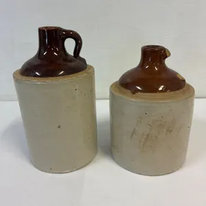 2 small pottery jugs. 1 broken handle. 8 & 7” tall