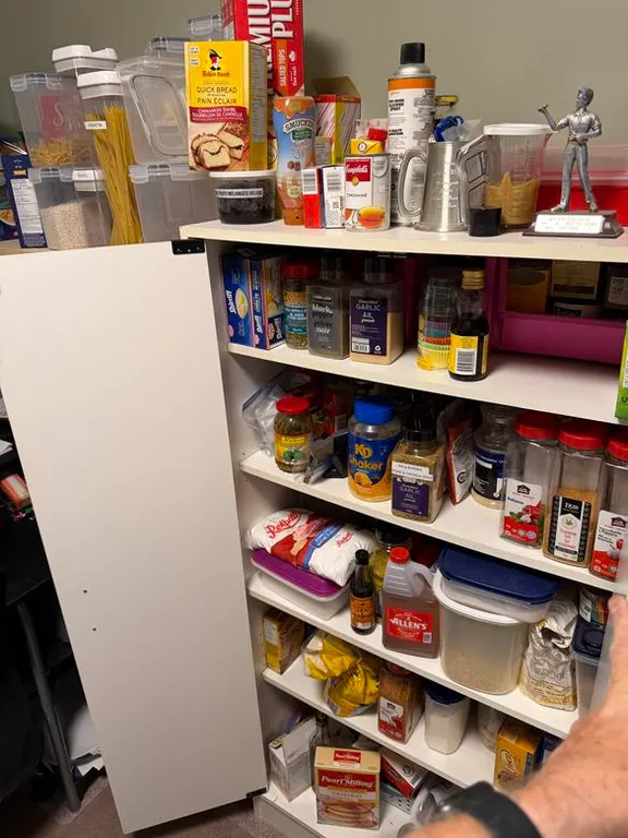 White Cupboard with Food Supply Inside and Above