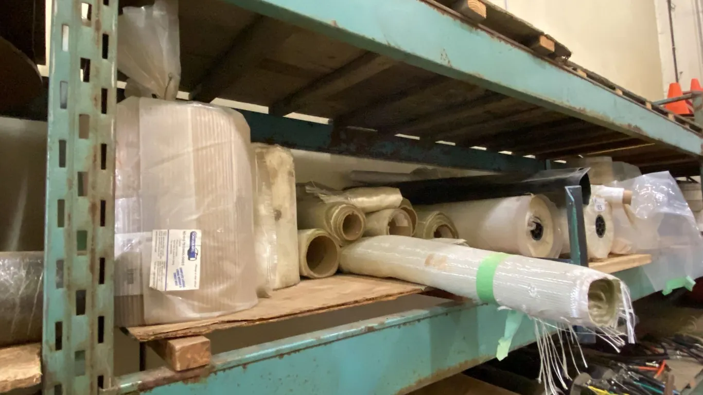 SHELF FULL OF ASSORTED ROLLS OF POLY & FIBERGLASS PIPE LINER