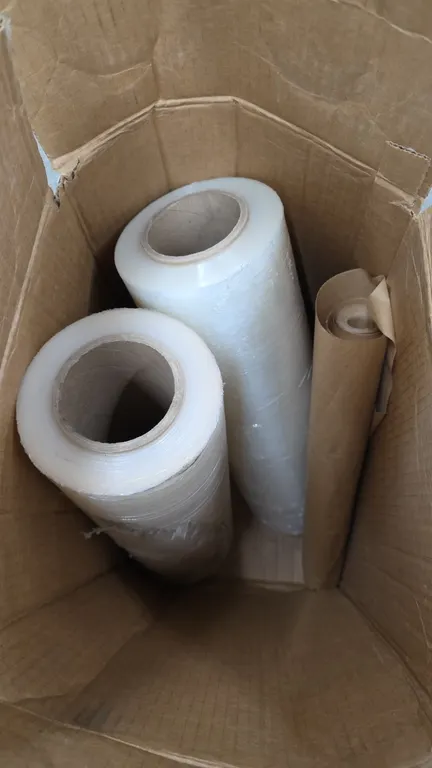 Uline S-3212 cast stretch wrap and packaging paper rolls. Includes two rolls of clear stretch film and one roll of kraft packing paper inside box.