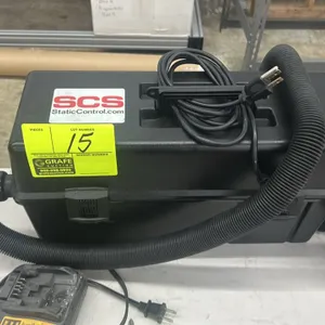 SCS electronic service vacuum. Features portable toolbox-style housing with integrated carrying handle, latched lid, flexible hose, and attached power