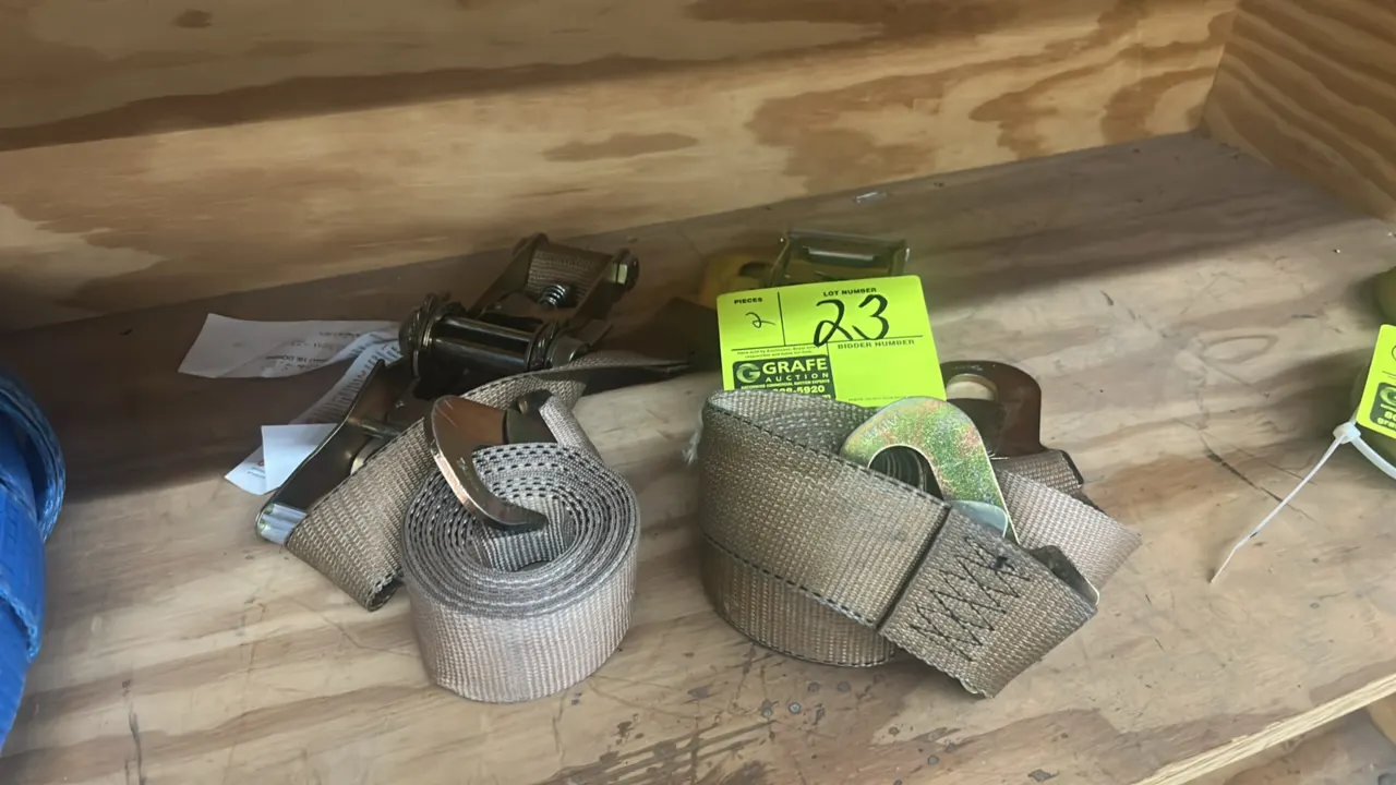 Nylon ratchet tie-down cargo straps. Features metal ratcheting mechanisms, flat snap hooks, and woven tan webbing.