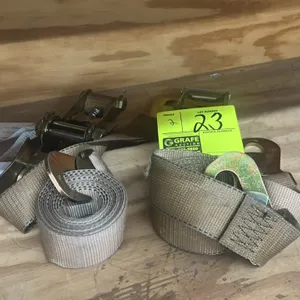 Nylon ratchet tie-down cargo straps. Features metal ratcheting mechanisms, flat snap hooks, and woven tan webbing.