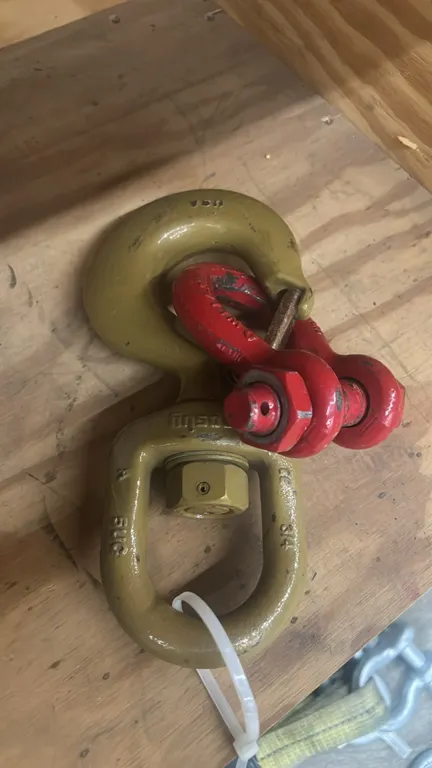 Crosby swivel lifting hook and alloy bolt-type anchor shackle. Features swivel eye hook with spring latch and red bolt-type anchor shackle with nut.