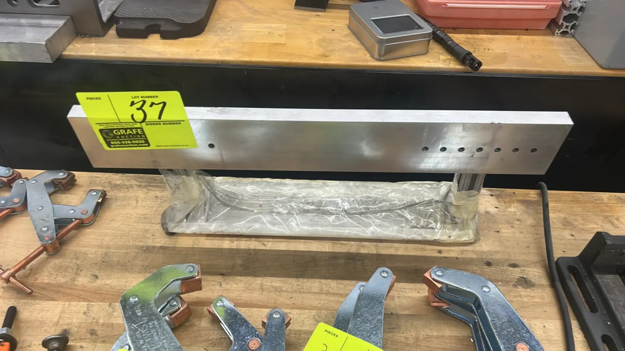 Aluminum framed magnet. Features solid aluminum bar with pre-drilled mounting holes and T-slot extruded aluminum standoffs. Lower magnetic bar wrapped