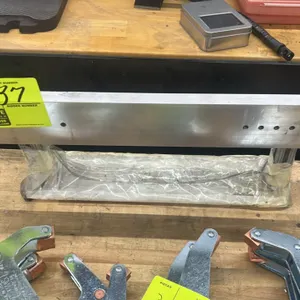 Aluminum framed magnet. Features solid aluminum bar with pre-drilled mounting holes and T-slot extruded aluminum standoffs. Lower magnetic bar wrapped