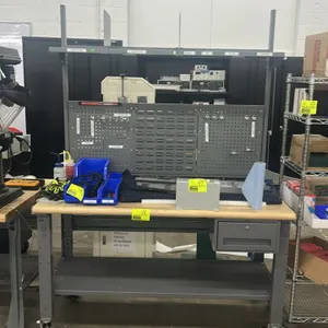 Portable metal workbench. Features wood top, lower storage shelf, single under-mount drawer, overhead shelf with dividers, and metal pegboard back pan
