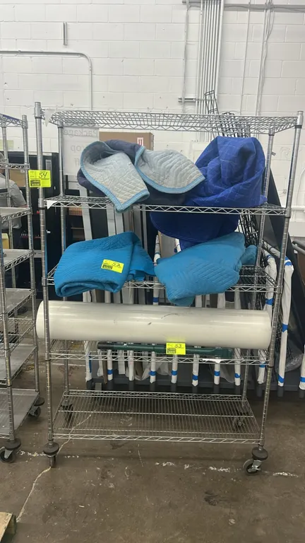 Multi-tier metal wire portable rack. Features (4) wire shelves and chrome finish. Dimensions: 48" x 18". Mounted on swivel casters with donut bumpers.