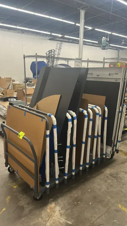 Metal material handling cart with assorted metal frames and panels. Includes multiple vertical divider bars and assorted metal panels/components. Dime