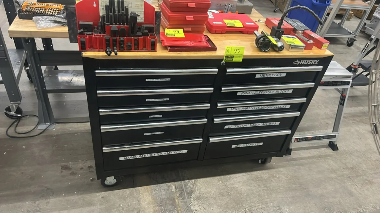 Husky 10-drawer mobile workbench. Features a solid hardwood top and black metal construction. 52" x 18". Mounted on swivel casters. Contents not inclu