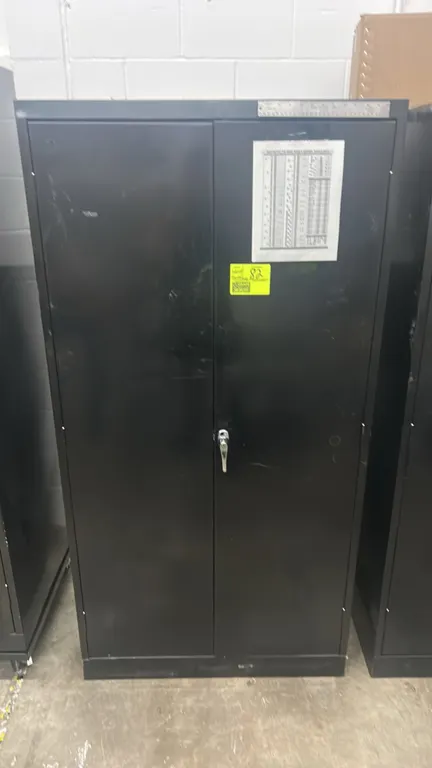 Tennsco metal 2-door locking cabinet. Features dual hinged doors, locking handle, and interior shelving. Includes sockets, safety glasses, safety head