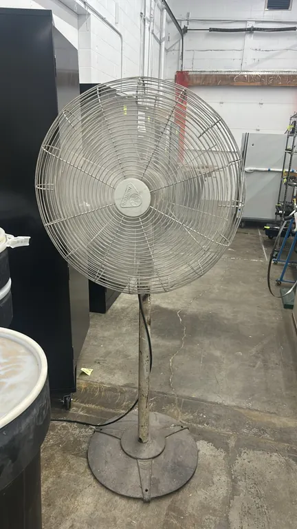 Hunter industrial pedestal fan. Features wire safety guard and circular pedestal base.