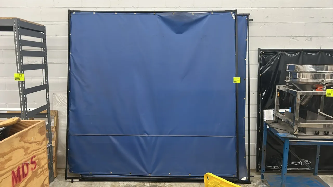 Metal-framed divider panels. Features black tubular metal frames with grommet-mounted blue vinyl barrier screens. Dimensions: 8' x 8'.