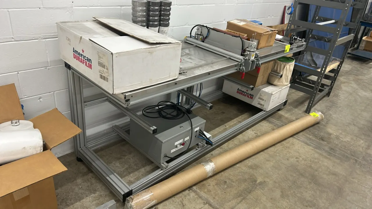 Custom-built industrial automated testing and handling rig. Features T-slot aluminum extrusion frame, stainless steel work surface, rail-mounted slidi
