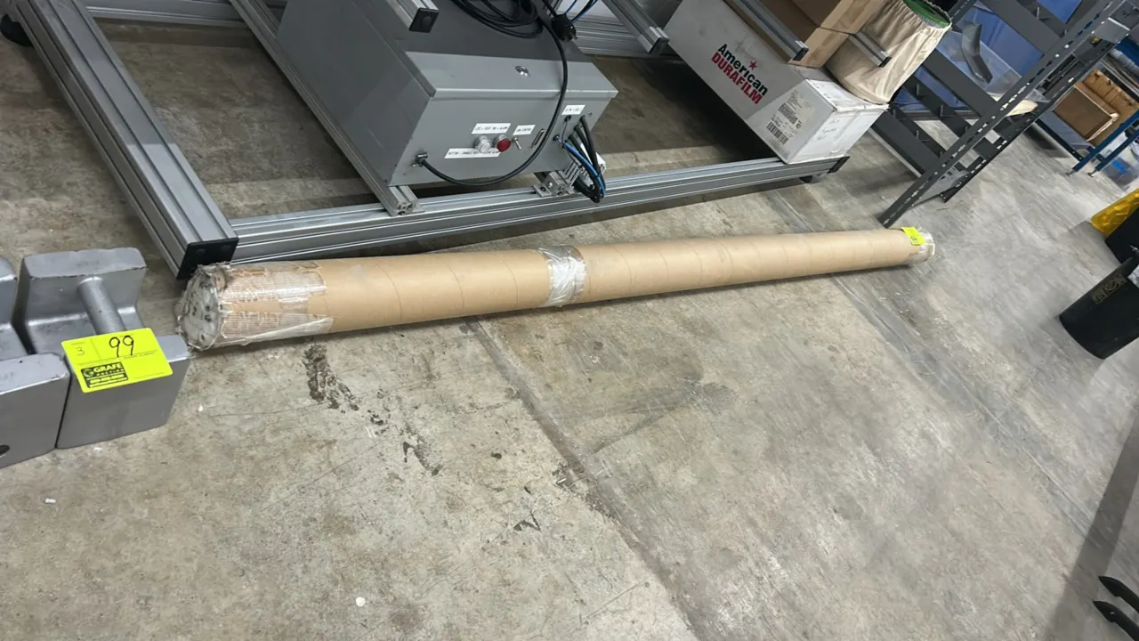 Assorted metal components in cardboard storage tube. Includes extruded profiles, mounting hardware, and related assembly parts.