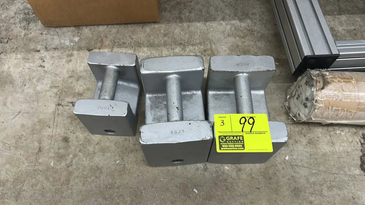 Cast iron grip-handle calibration weights. Includes (2) 50 lb weights and (1) 25 lb weight. Features silver-painted finish and integrated carry handle