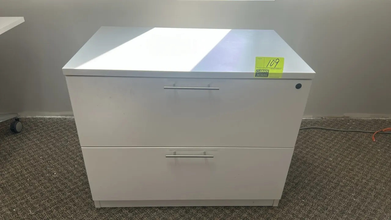 Two-drawer laminate lateral file cabinet. Features white laminate construction with silver-tone bar pull handles.
