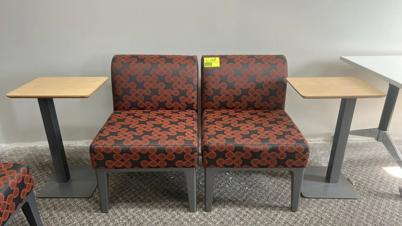 Cushioned waiting room chairs with side tables. Features patterned upholstery, armless design, and square wood-look laminate side tables on metal pede