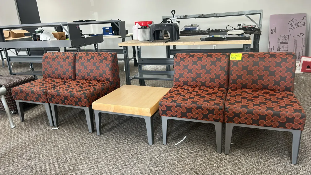 Waiting room seating and table set. Includes (4) armless cushioned reception chairs with patterned upholstery and (1) square wood-finish low accent ta