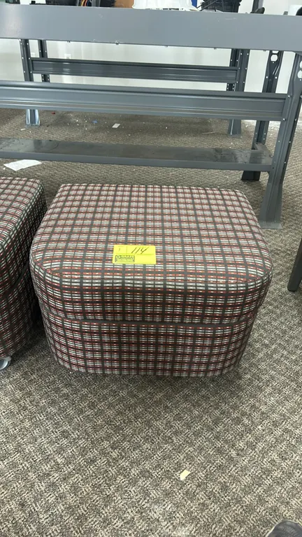 Cushioned rolling ottoman. Features patterned fabric upholstery and padded top. Mounted on casters.
