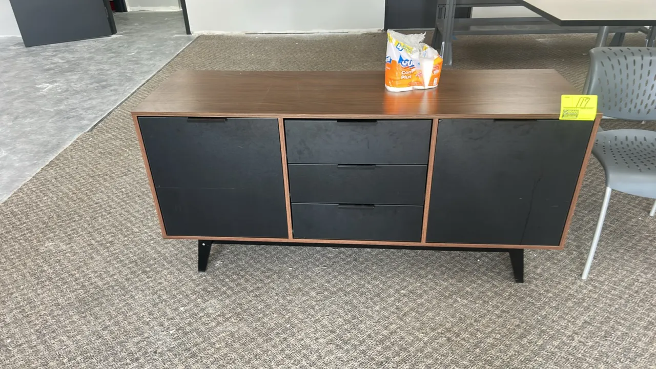 Laminate storage cabinet credenza. Features woodgrain finish, 3 center drawers, and 2 side storage compartments with black fronts and edge pull handle