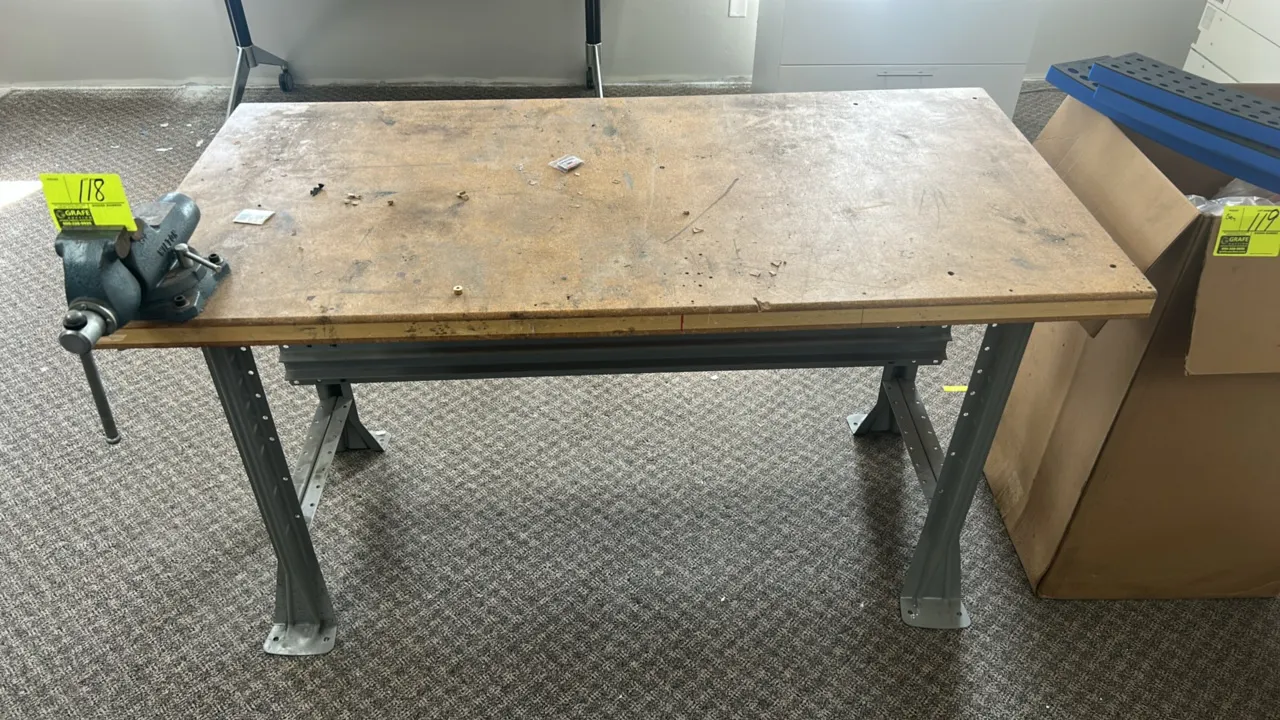 Metal frame workbench with Wilton Tradesman vise. Features corkboard/composite work surface and a mounted Wilton Tradesman swivel base bench vise. 60"
