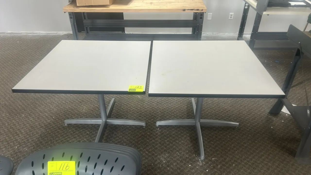 Laminate tables. Features square light gray laminate tops with black protective edge banding. 3' x 3'. Mounted on silver-tone metal 4-prong pedestal b