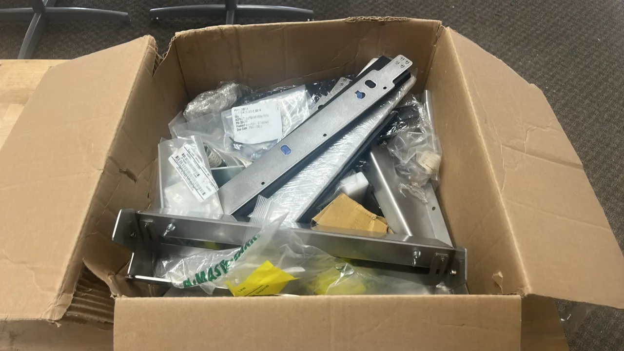 Assorted metal parts and hardware. Includes stainless steel brackets, metal plates, slide components, and various bagged hardware.