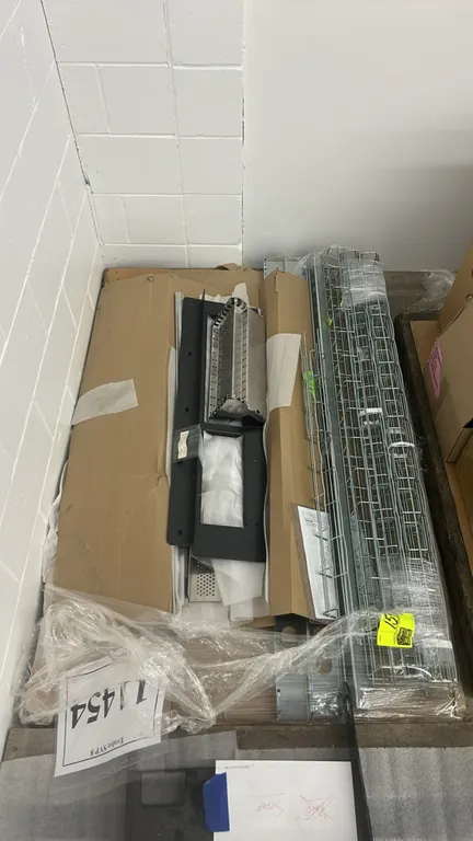 Assorted metal framing components and wire mesh cable trays. Includes metal mounting panels, perforated brackets, and wire raceway channels.