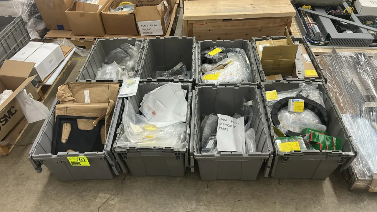 Assorted components and fabricated parts in storage totes. Includes Evolve fabricated parts and brackets, Hiwin H25H linear guideway blocks, Ashcroft