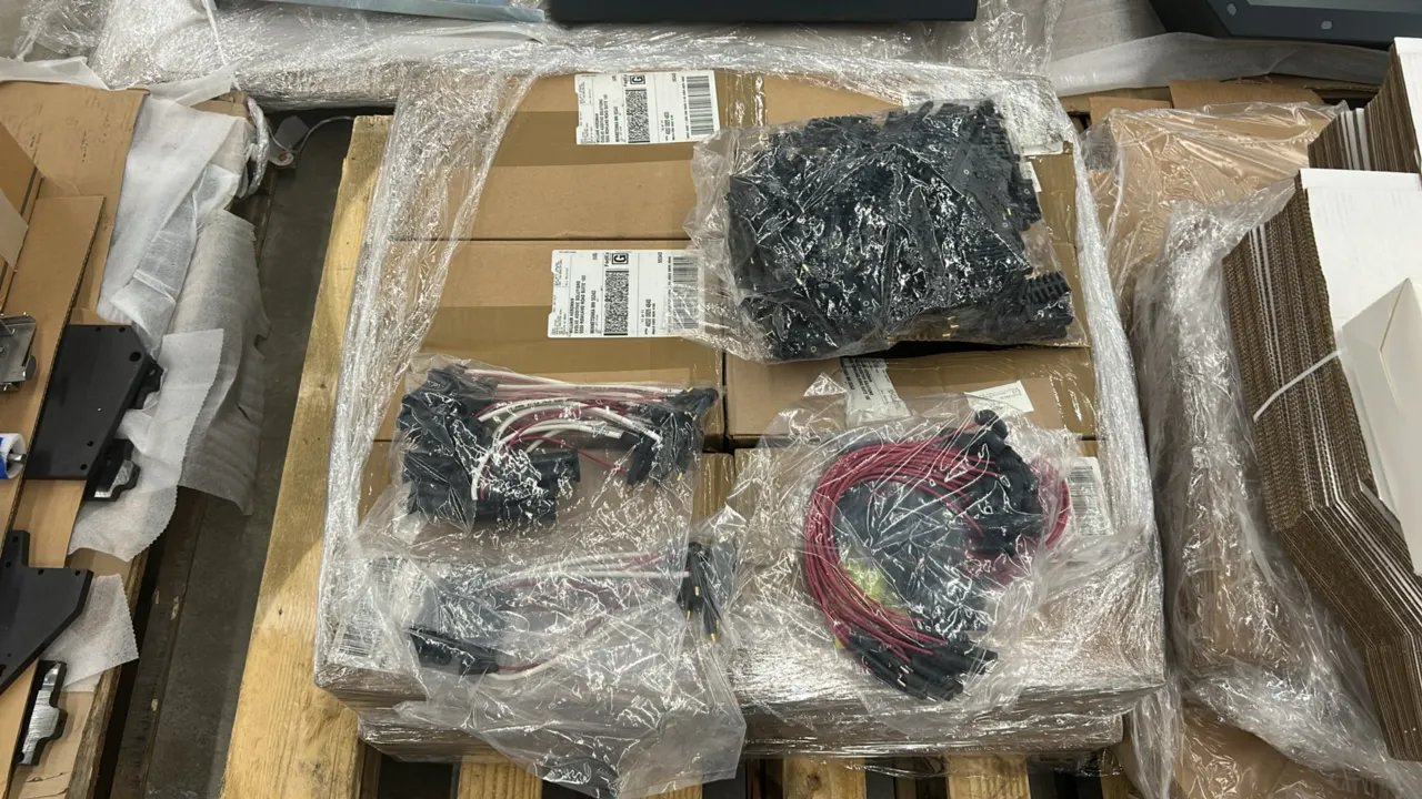 Bulk pallet lot of industrial hardware and wiring components. Includes wire harness assemblies with connectors, molded terminal components, and boxed