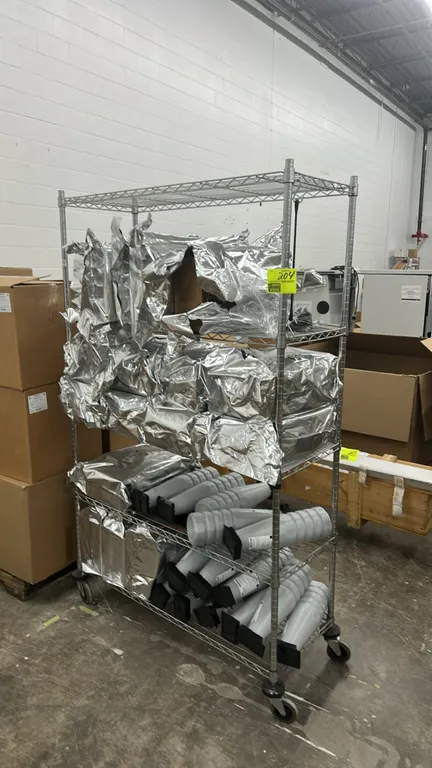 Metal multi-tier wire shelf cart with quantity of Evolve printer toner bottles. Features 4-tier wire construction. 48" x 18". Mounted on swivel caster