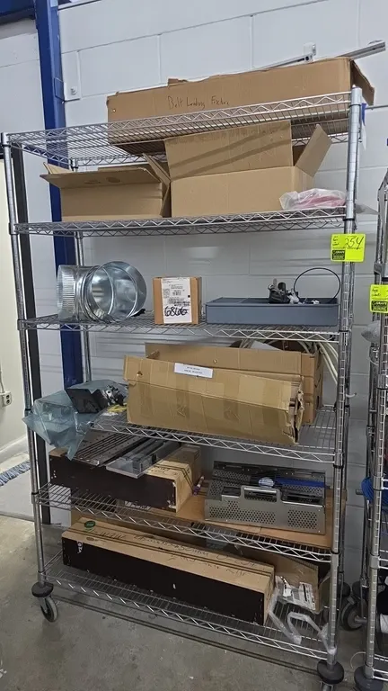 Portable chrome 6-tier wire shelving cart. Features 6 wire shelves. Includes an assortment of various parts, fixtures, hardware, pneumatics, and compo