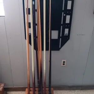 Assortment of pool cues and floor stand