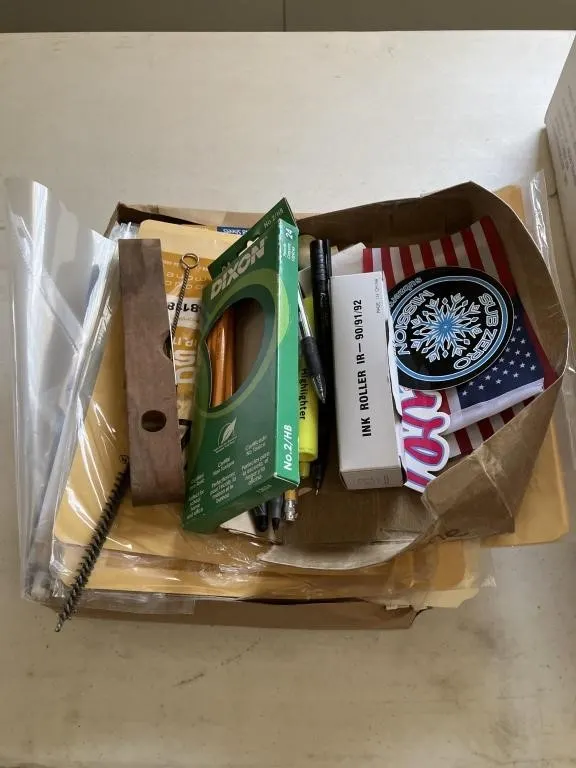 Box of various office supplies and memo books.